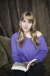 Young Woman with Beautiful Blue Eyes Reading a Book