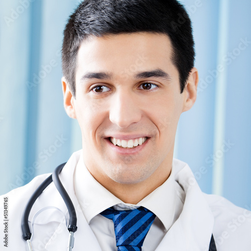Photo: Happy smiling young doctor at office Happy smiling young doctor at office