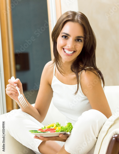 Photo: Young woman with salad, at home Young woman with salad, at home