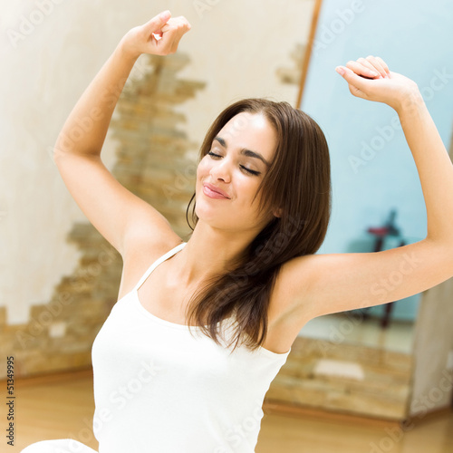 Photo: Young woman waking up on bed Young woman waking up on bed