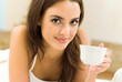 Young happy smiling woman drinking coffee, at home