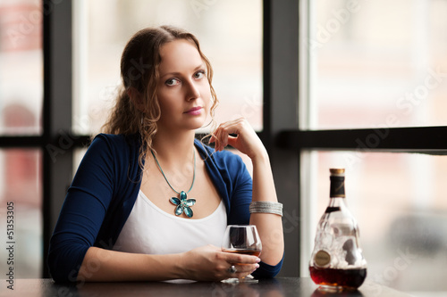 Photo: Beautiful young woman with cognac at restaurant Beautiful young woman with cognac at restaurant