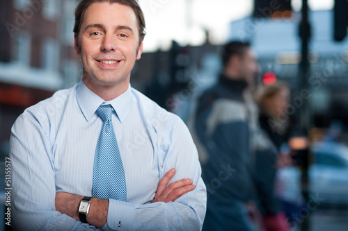 Photo: Confident businessman posing, street background Confident businessman posing, street background