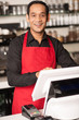 Photo: Cheerful barista staff at the cash counter Cheerful barista staff at the cash counter