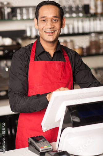 Photo: Cheerful barista staff at the cash counter Cheerful barista staff at the cash counter