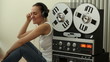 Girl in headphones listening to music from retro tape recorder