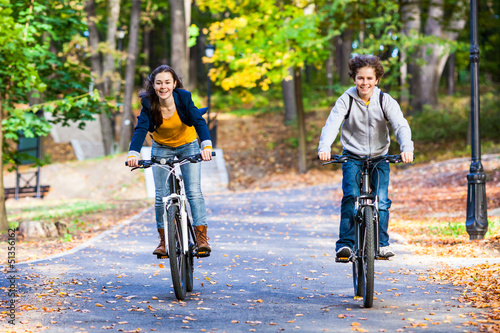 Photo: Urban biking - teens riding bikes in city park Urban biking - teens riding bikes in city park