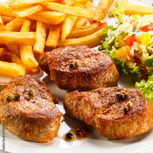 Photo: Grilled steaks, French fries and vegetables Grilled steaks, French fries and vegetables