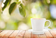 Cup of hot drink on summer background, free space for text
