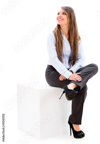 Photo: Businesswoman sitting on a cube. Businesswoman sitting on a cube.