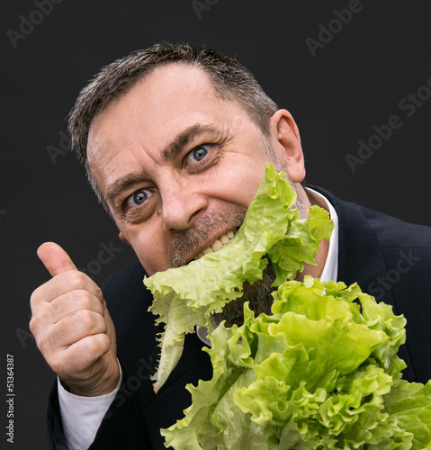 Photo: Man holding and eating lettuce Man holding and eating lettuce