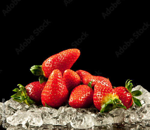 Photo: strawberry on black background. strawberries with ice cubes on strawberry on black background. strawberries with ice cubes on