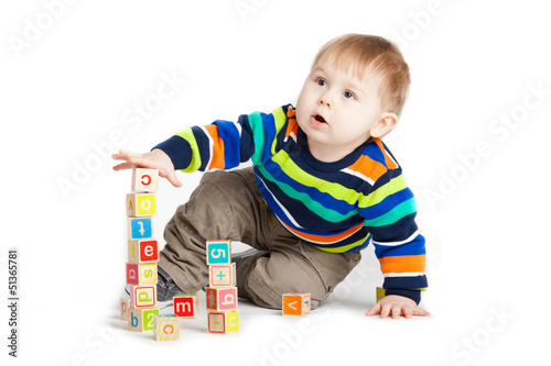 Photo: baby playing with wooden toy cubes with letters. Wooden alphabet baby playing with wooden toy cubes with letters. Wooden alphabet