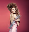 Beautiful young lady wearing pink elegant dress over pink backgr