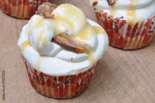 Photo: Muffins with whipped cream on a worktop Muffins with whipped cream on a worktop