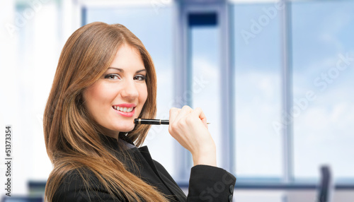 Photo: Smiling woman holding a pen Smiling woman holding a pen