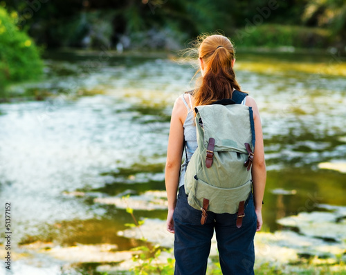 Photo: Young woman hiking with backpack Young woman hiking with backpack