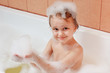 Little cute smiling boy bathes in a bathroom