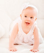 little cute girl in a white dress and with flower smiling