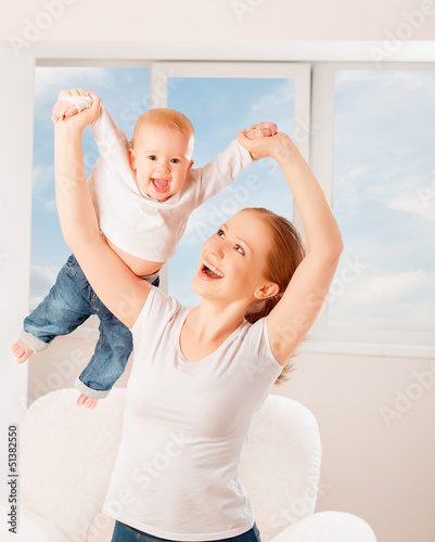 Photo: Mother and baby are playing active games, do gymnastics and laug Mother and baby are playing active games, do gymnastics and laug