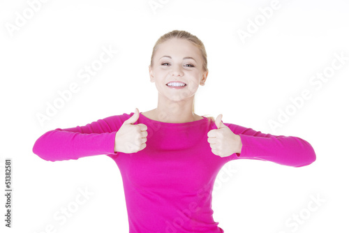 Photo: Young casual woman gesturing thumbs up. Young casual woman gesturing thumbs up.