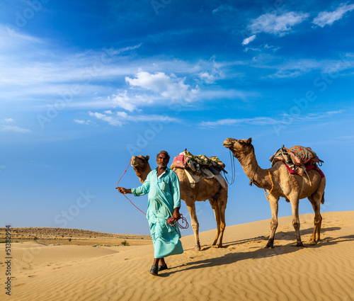 Photo: Cameleer (camel driver) with camels in dunes of Thar desert. Raj Cameleer (camel driver) with camels in dunes of Thar desert. Raj