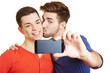 Schwuler Mann küsst Partner und macht Foto mit Scmartphone