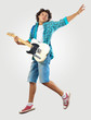 young man playing on electro guitar and jumping