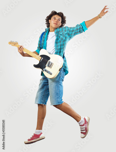 Photo: young man playing on electro guitar and jumping young man playing on electro guitar and jumping