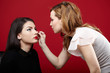 Woman having makeup applied by makeup artist