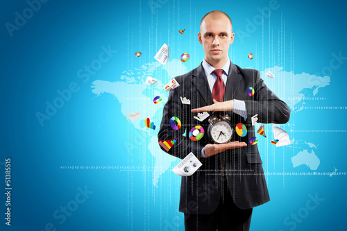 Photo: Business man holding alarmclock Business man holding alarmclock