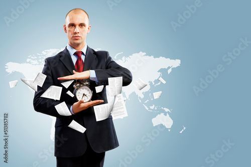 Photo: Business man holding alarmclock Business man holding alarmclock
