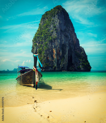 Photo: Long tail boat on beach, Thailand. Cross process vintage style Long tail boat on beach, Thailand. Cross process vintage style