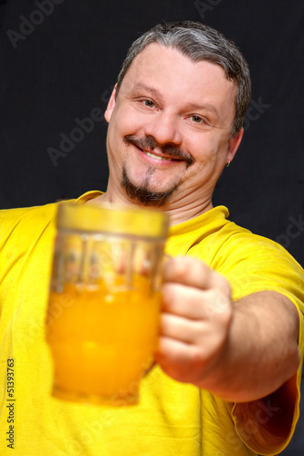 Photo: dark smiling man holding a glass of beer dark smiling man holding a glass of beer