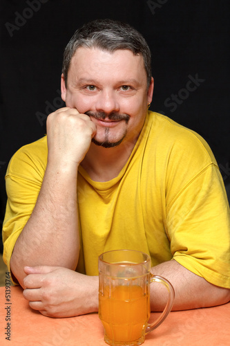 Photo: dark smiling man holding a glass of beer dark smiling man holding a glass of beer