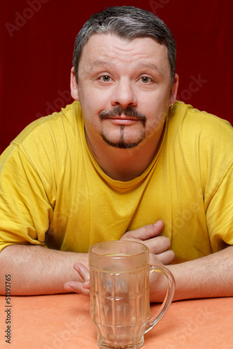 Photo: dark man looks at an empty beer mug dark man looks at an empty beer mug