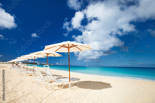 Photo: Chairs and umbrellas on tropical beach Chairs and umbrellas on tropical beach