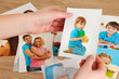 Photos in hands on wooden table