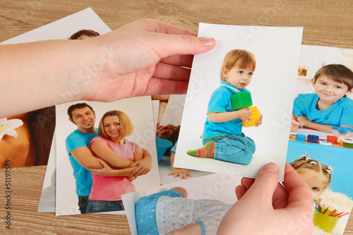 Photo: Photos in hands on wooden table Photos in hands on wooden table