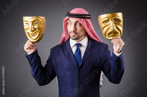 Photo: Arab with masks in dark studio Arab with masks in dark studio