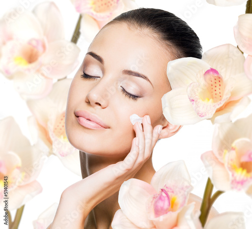 Photo: woman applying cosmetic cream on face woman applying cosmetic cream on face