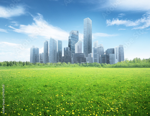 Photo: field of spring flowers and modern city field of spring flowers and modern city