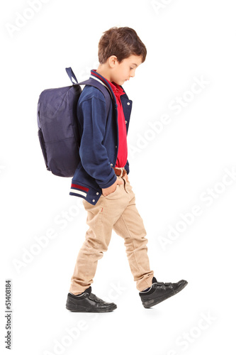 Photo: Full length portrait of a sad school boy walking Full length portrait of a sad school boy walking