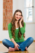 Young woman at home on the phone