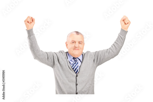 Photo: A mature gentleman seated on a table gesturing happiness A mature gentleman seated on a table gesturing happiness