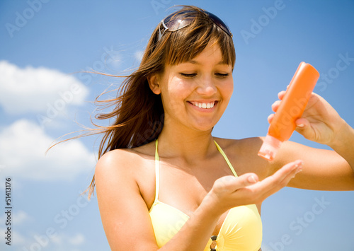 Photo: woman in bikini smear protective cream woman in bikini smear protective cream