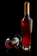 Bottle and glass of cognac over black background