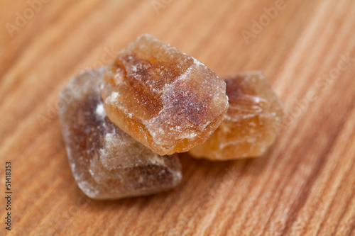 Photo: brown caramelized sugar on wooden background brown caramelized sugar on wooden background