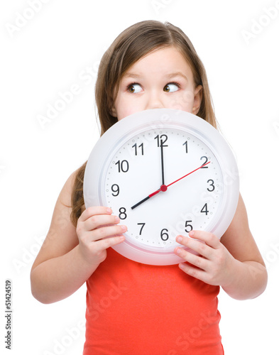 Photo: Little girl is holding big clock Little girl is holding big clock