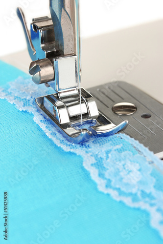 Photo: Closeup of sewing machine working part with blue cloth Closeup of sewing machine working part with blue cloth